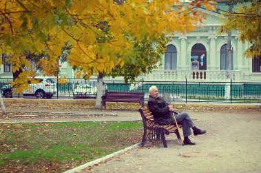 Personne âgée assis sur un banc dans un parc